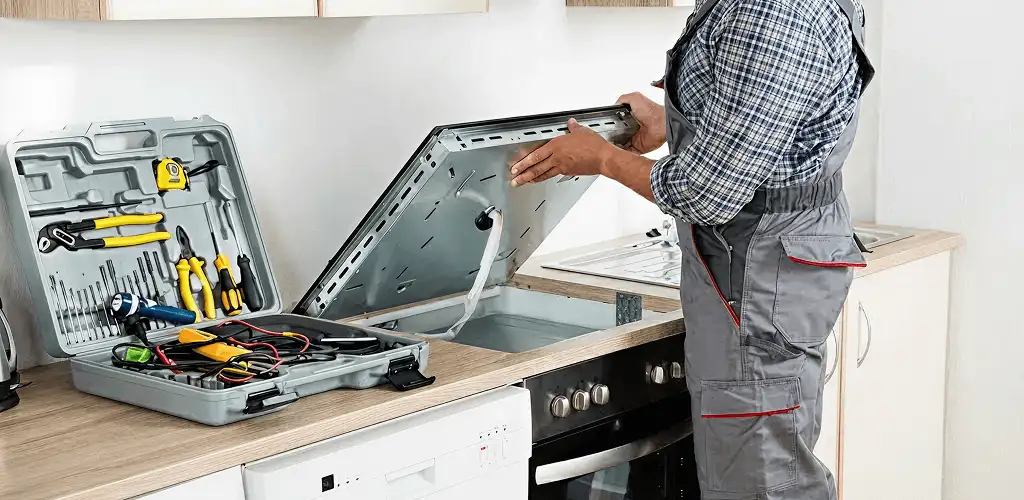 Handyman repairing a cooktop and checking wiring connections in Knoxville, TN