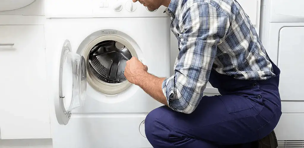 Handyman inspecting a dryer drum and internal parts for repair in Knoxville, TN