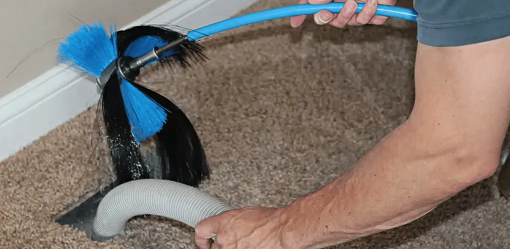 Dryer vent cleaning technician brushing lint from a vent line in Knoxville, TN