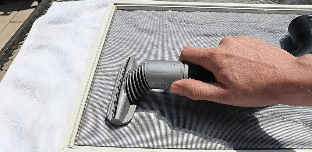 Window screen repair cleaning and fixing a damaged screen mesh in Knoxville, TN